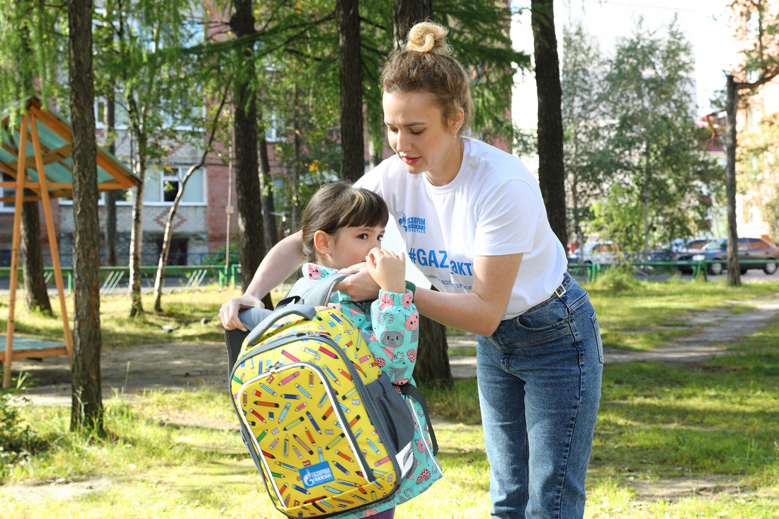Волонтер GAZ_актива вручает рюкзак будущей первокласснице из Донбасса