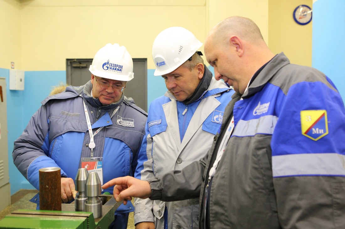 Главный инженер Алексей Кононов (слева) оценивает результат конкурсной работы одного из токарей