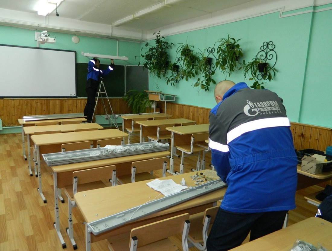 Сотрудники ООО "Газпром добыча Ноябрьск" производят замену старых ламп на энергосберегающие в одной из ноябрьских школ